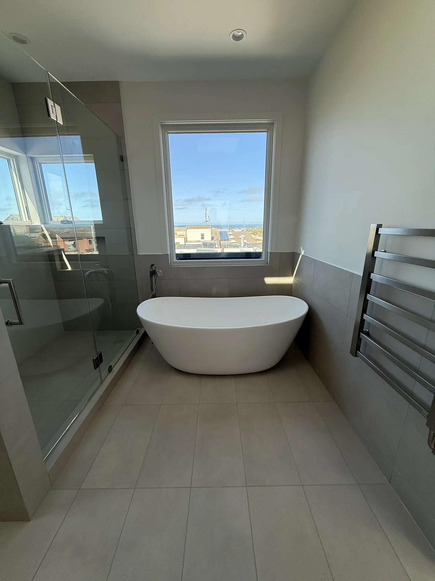 Elegant white ceramic bathtub near window